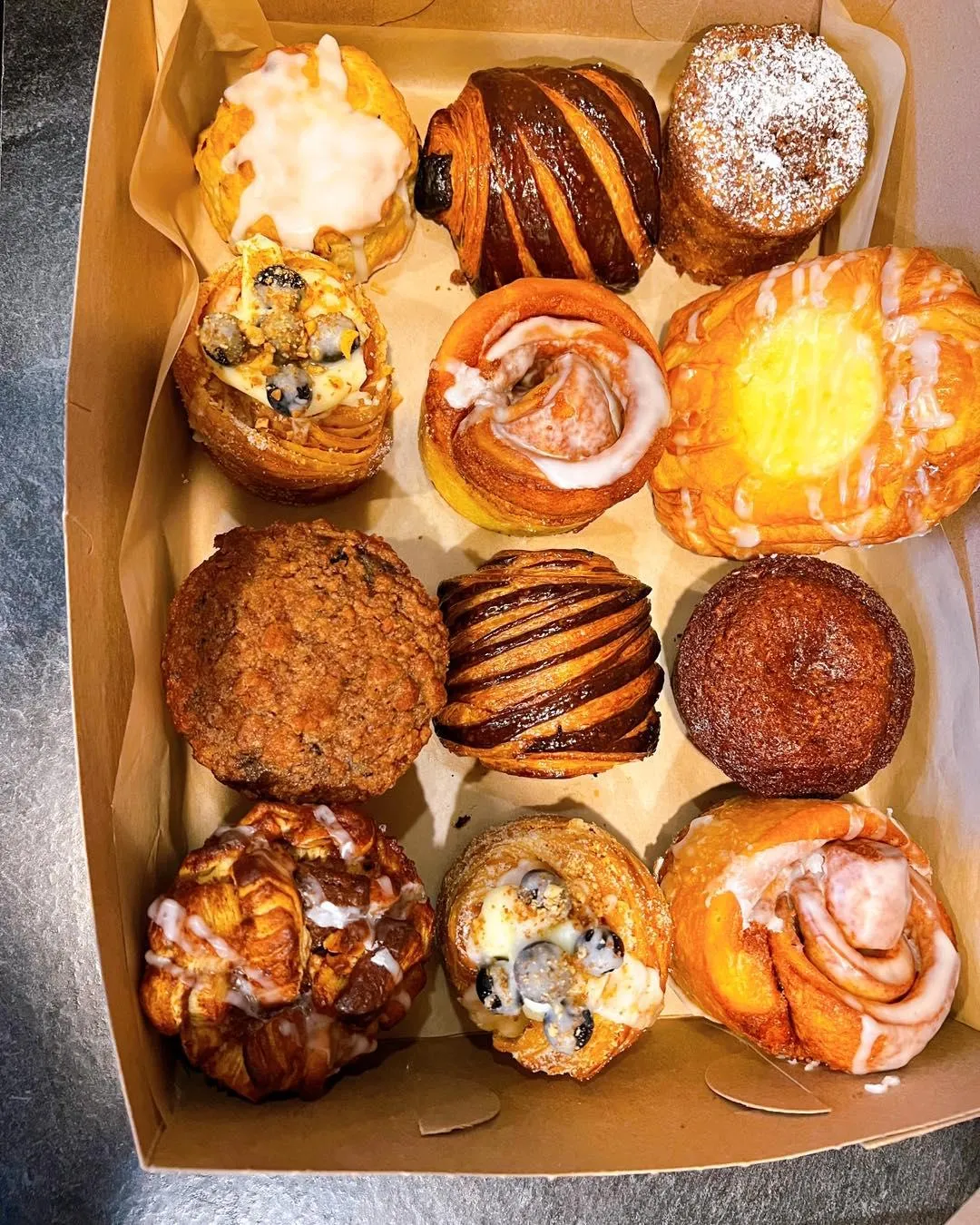 A dozen assorted Niko's pastries in a box: croissants, danishes, muffins and cruffins